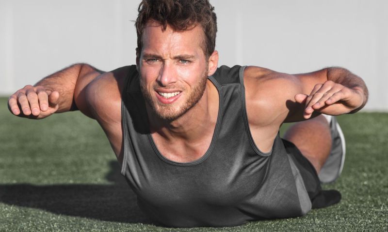 Man doing Superman exercise outside