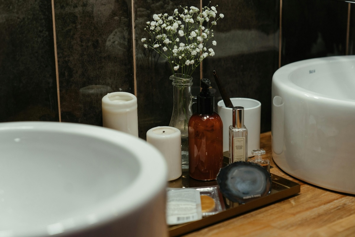 skincare products on brown tray with baby's breath flower by bathroom sink